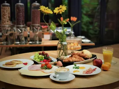 a table topped with plates of food and cups of coffee at Chasse Residency Hotel in Amsterdam