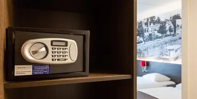a digital clock on a shelf in a hotel room at Bastion Hotel Bussum Hilversum in Bussum
