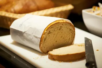 a piece of bread on a plate with a knife at Bastion Hotel Leiden Oegstgeest in Oegstgeest