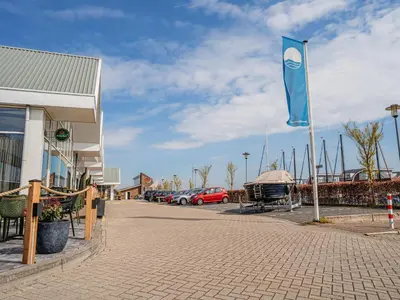 a blue flag on a pole in a parking lot at Apartment in Waterpark with Private Jetty in Uitgeest