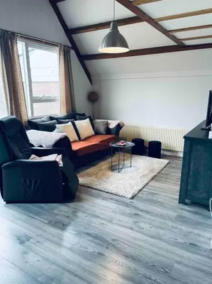 a living room with a couch and a table at Leuke bungalow in Noord-Holland in Opmeer