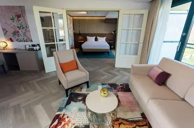 a living room with a couch and a table and a bed at DoubleTree by Hilton Royal Parc Soestduinen in Amersfoort