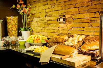 a buffet with bread and other foods on a table at Fletcher Hotel Restaurant Marijke in Bergen