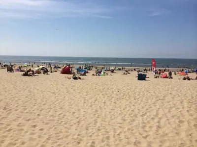 a group of people sitting on a beach at Strand83 in Egmond aan Zee
