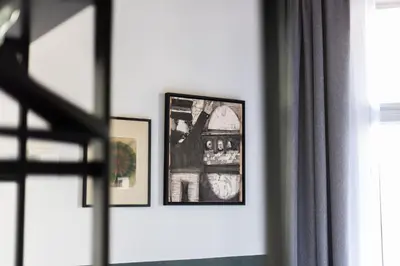 two framed pictures on a wall next to a window at Weber Hotel in Amsterdam