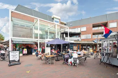 a group of people sitting at tables in front of a building at 't Schelpje with free parking in Zandvoort