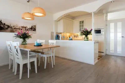 a kitchen and dining room with a table and chairs at Sterflat 99 in Egmond aan Zee