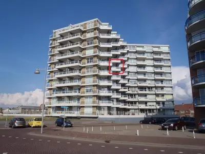 a large apartment building with a red circle on it at Sterflat 157 in Egmond aan Zee