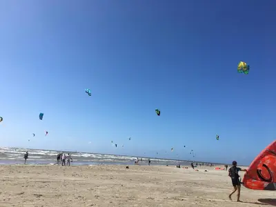 a group of people on the beach flying kites at DD 58 - Camping de Duindoorn - AIRCO in IJmuiden