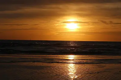 a sunset on the beach with the ocean at Solaris in Egmond aan den Hoef