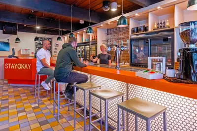 a group of people sitting at a bar at Stayokay Hostel Noordwijk in Noordwijk