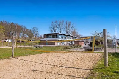 a volleyball court with a net in front of a building at Stayokay Hostel Noordwijk in Noordwijk