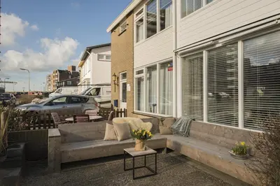 a couch sitting in front of a building at Strandhuis 122 Studio in Egmond aan Zee