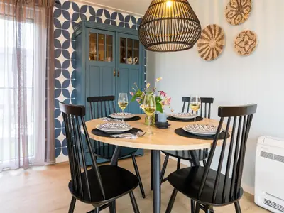 a dining room table with chairs and a chandelier at Holiday home in 't Groene Hart on the water in Oud-Ade