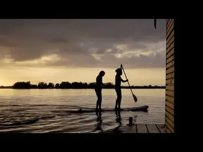 two people standing on a paddle board in the water at Houseboat Tjonger NS003 in Monnickendam