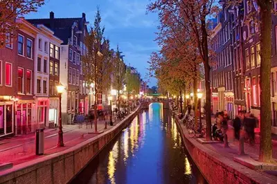 a canal in a city at night with people walking around at Houseboat Tomio near Amsterdam in Monnickendam