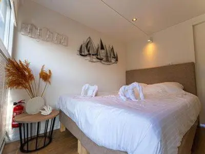 a bedroom with a bed with sails on the wall at Comfi Houseboat Maatrollie in Monnickendam close to Amsterdam in Monnickendam
