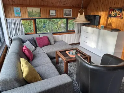 a living room with a couch and a table at Bungalowpark in Nordholland in Opmeer