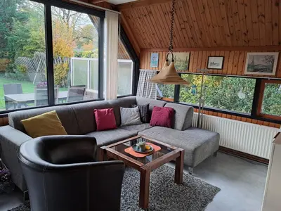 a living room with a couch and a table at Bungalowpark in Nordholland in Opmeer