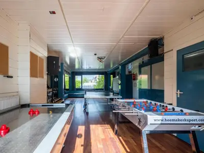 a row of ping pong tables in a room at De Kaag Watersport Groepsaccommodatie - 30 pers in Kaag