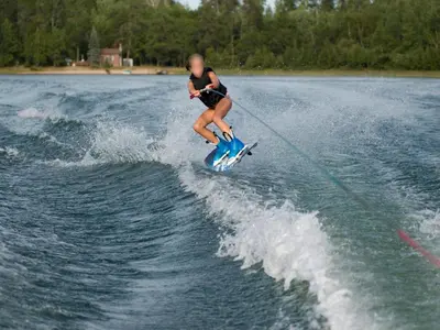 a woman water skiing on a board in the water at De Kaag Watersport Groepsaccommodatie - 30 pers in Kaag