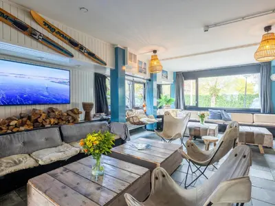 a living room with a couch and a table at De Kaag Watersport Groepsaccommodatie - 50 pers in Kaag