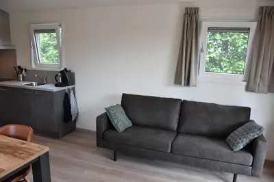 a living room with a couch and a sink at Chalet 4, Recreatie aan de Vecht in Weesp
