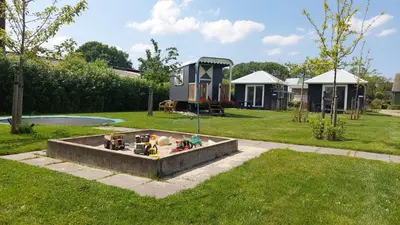 a tiny house in a yard with a backyard at Chalet 4, Recreatie aan de Vecht in Weesp