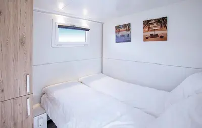 a small bedroom with two beds and a window at Davy Jones in Almere