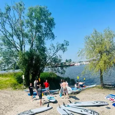 a group of people standing on a beach with surfboards at Houseboat Oslo perfect voor bezoek Amsterdam in Monnickendam