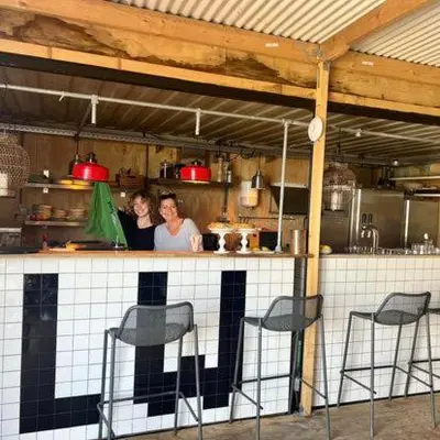 two people standing at a counter in a kitchen at Houseboat Oslo perfect voor bezoek Amsterdam in Monnickendam