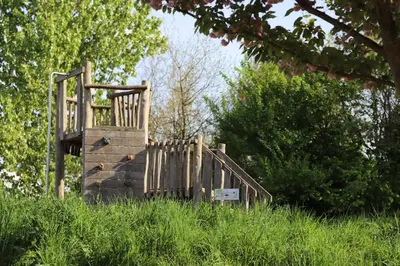 a wooden playground in a field of tall grass at Safari Lodges in Nieuwe Wetering