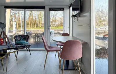 a dining room with a table and chairs and a window at Johannesburg in Naarden