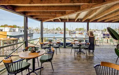a restaurant with tables and chairs and a marina at Johannesburg in Naarden