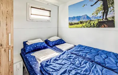 a bedroom with a bed and a painting on the wall at Trancoso in Naarden