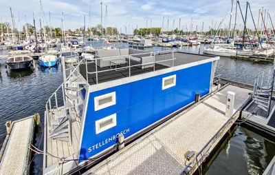 a blue boat is docked at a marina at Kaapstad in Naarden