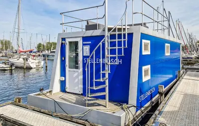 a blue boat docked at a dock in the water at Brussel in Naarden