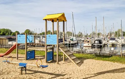 a playground with a slide in the sand near a marina at Brussel in Naarden