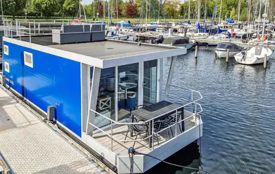a blue boat docked at a marina with boats at Monaco in Naarden