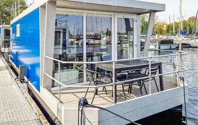 a dock with a table and chairs on a boat at Monaco in Naarden