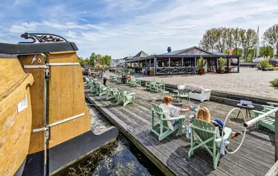 two girls sitting in chairs on a wooden dock at Monaco in Naarden