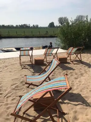 a group of chairs sitting on a sandy beach at Design huisje vrij in het groen in IJsselstein