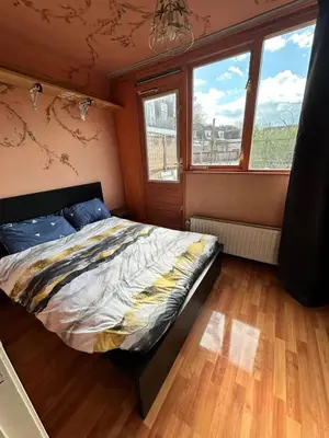 a bedroom with a bed in a room with windows at Terraced Bedroom in Utrecht