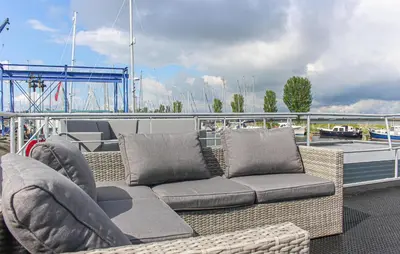 a wicker couch and chairs sitting on a boat at Havenlodge Lelystad in Lelystad