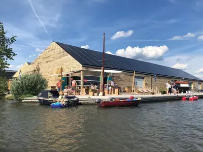 a building with people on boats on the water at Dobberhuisje in IJsselstein