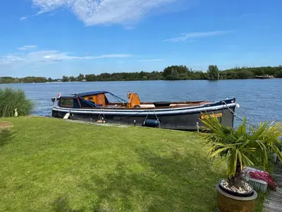 a boat is docked on the shore of a lake at 1-2 pp ROOM AMS Airport great view lake in Roelofarendsveen