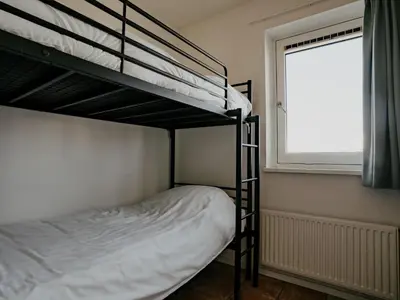 a bedroom with two bunk beds and a window at Oostergeest in Uitgeest