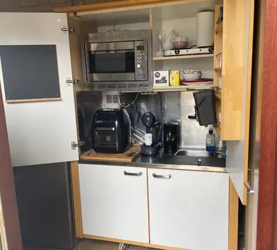a small kitchen with white cabinets and a microwave at 1-2 P Room near Airport AMS freeparking in Roelofarendsveen