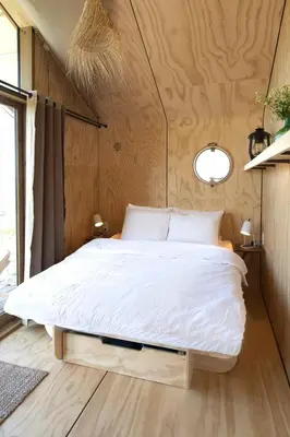 a bedroom with a large bed in a small room at Lakehouses luxe family holiday house 6 pers in Oud-Ade