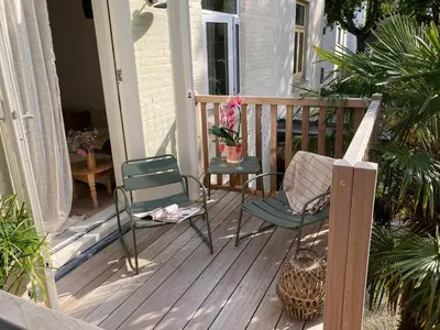 a porch with two chairs and a vase of flowers at Villa Magnolia in Bergen